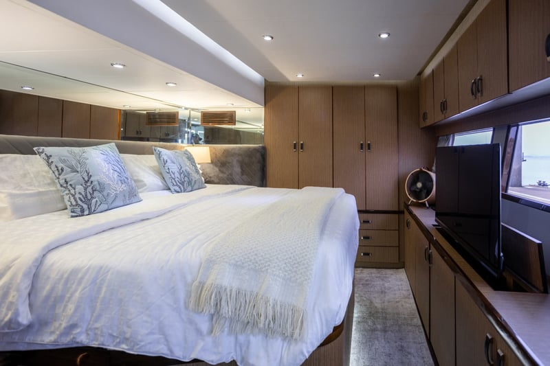 Owner's cabin with a king bed, full-length storage and a TV.