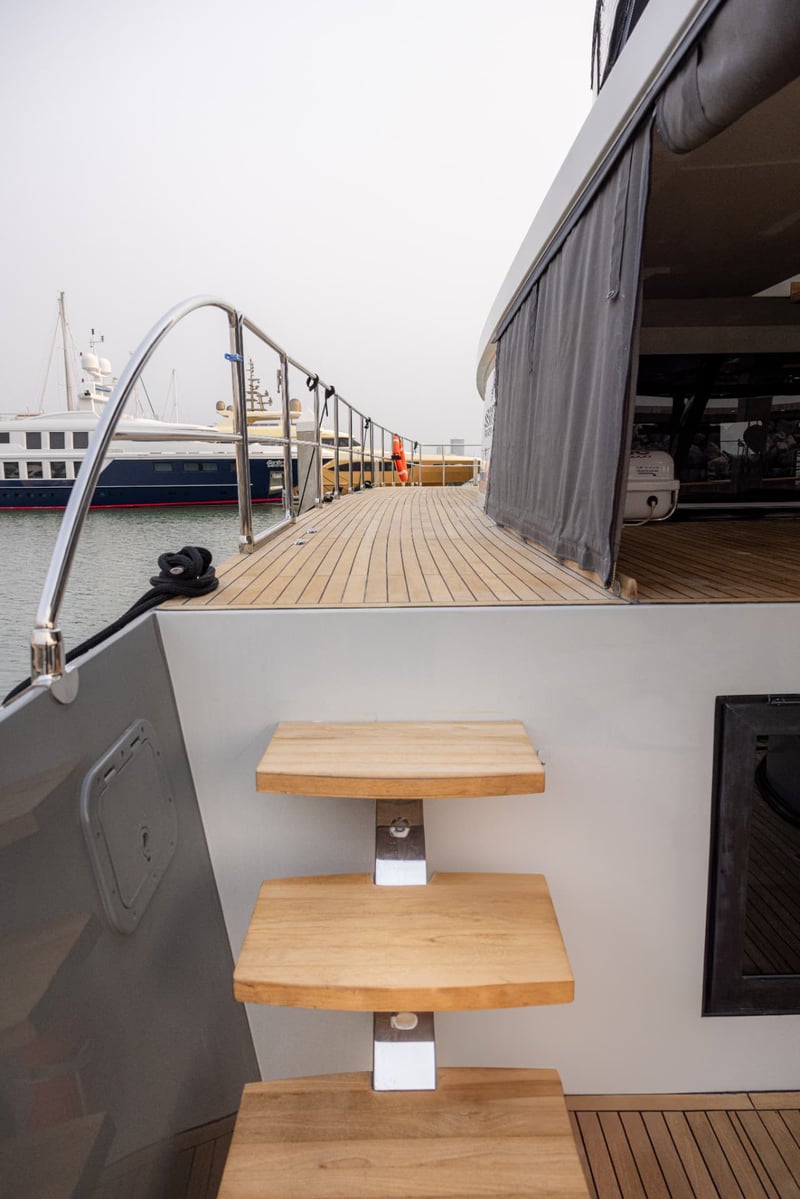 Wide side decks with teak steps and grab rails from bow to stern.