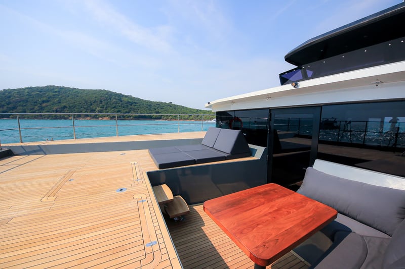 Bow seating with a timber table for lunch in front of the view.