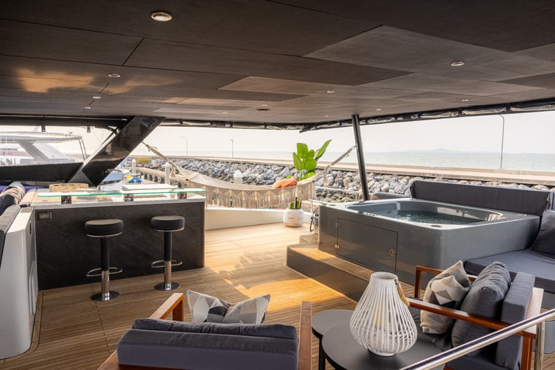 Flybridge bar and spa pool, with lounge chairs facing the water.