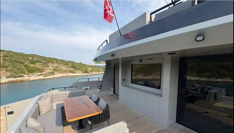 Aft deck dining table and lounge beside the salon doors