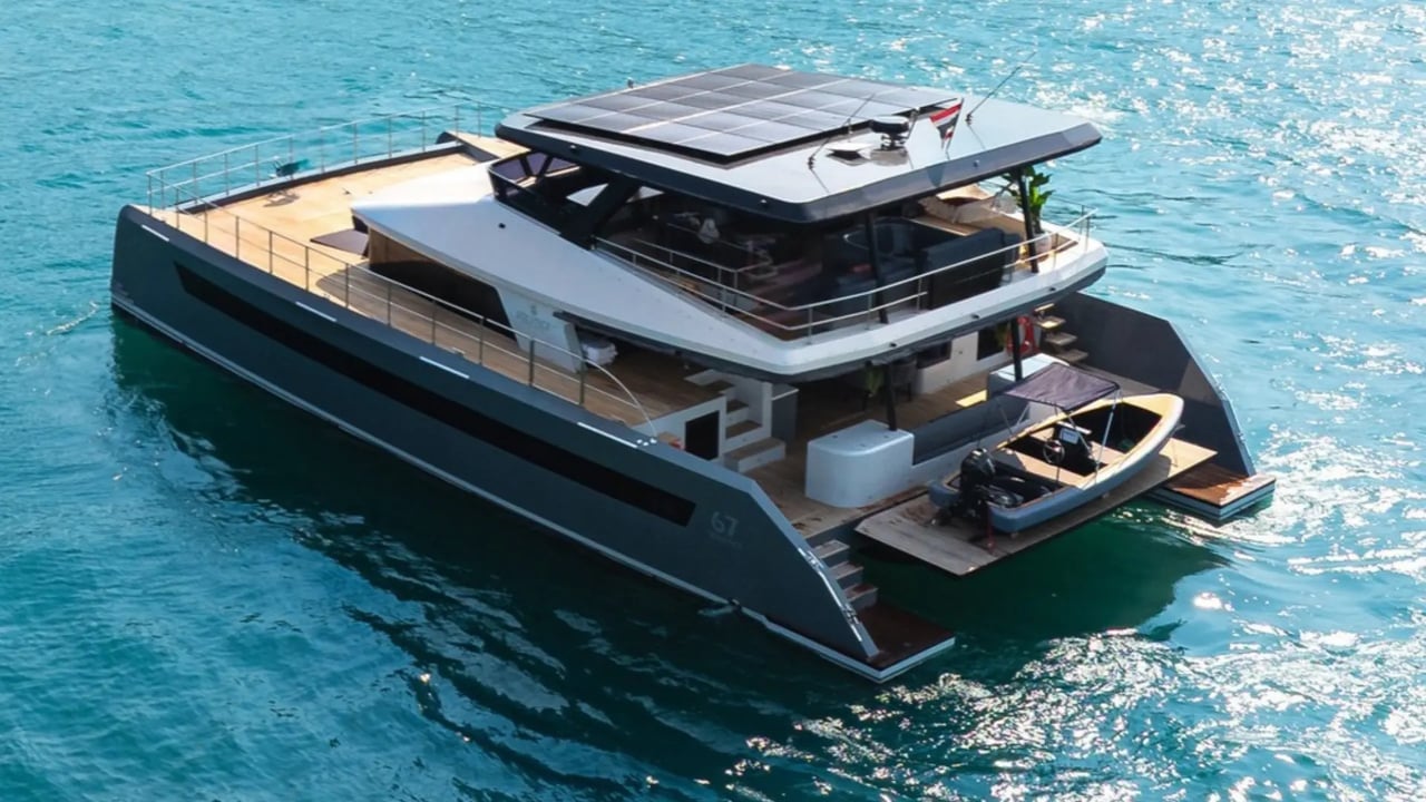 Independence 67 catamaran from above at sea, showing the solar hardtop, teak decks and tender on the stern platform