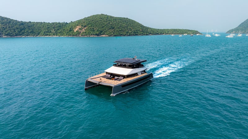 Underway in a turquoise bay. Twin hulls leave a clean, quiet wake.